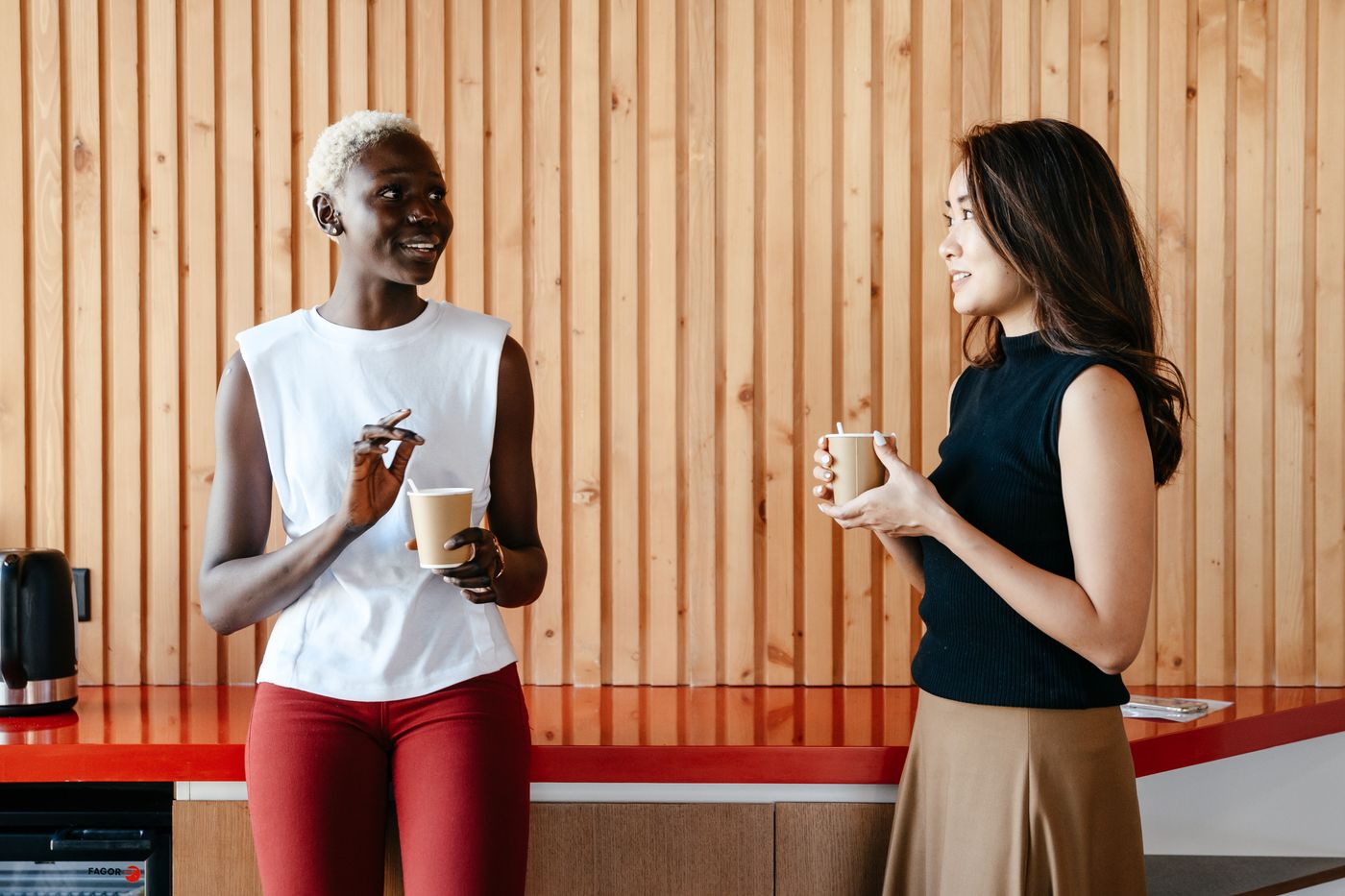 Professionals speaking over coffee in an office pantry